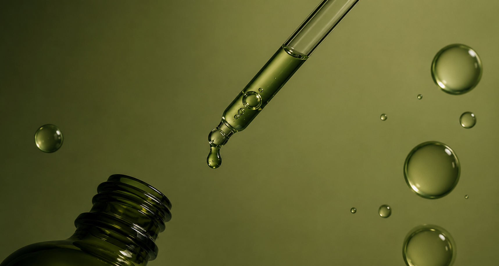 Gotero con sérum y burbujas sobre un fondo verde